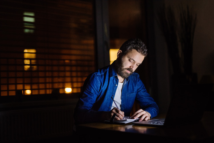 A-man-working-on-a-laptop-at-home-at-night